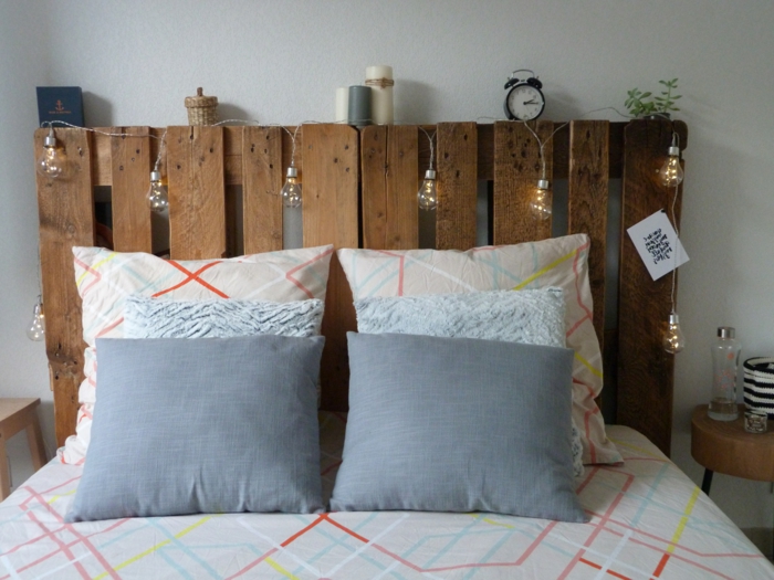 une tête de lit en palette décorée avec de petites lampes