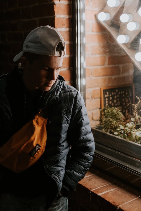 modele-de-de-sac-banane-coloré-à-porter-avec-streetwear-noir tenue décontracté homme de couleur noire avec un sac banane orange
