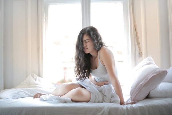 douleurs causées par de la constipation, fille au lit qui a mal de ventre