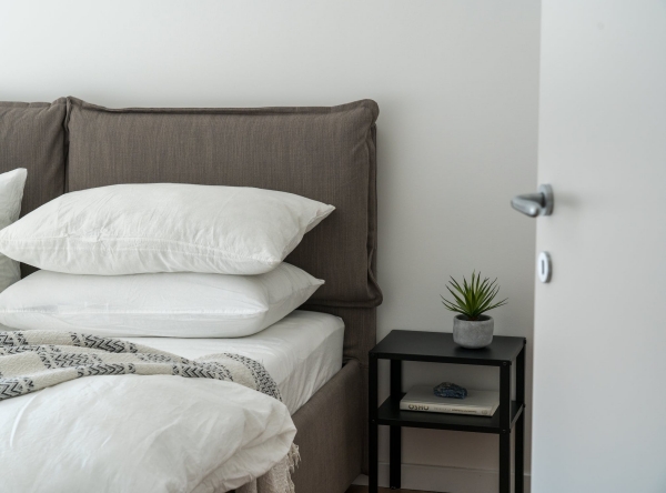 cadre de lit tissu deco chambre minimaliste table de chevet noir plante verte déco chambre à coucher adulte avec gros lit en tissu gris et literie blanche