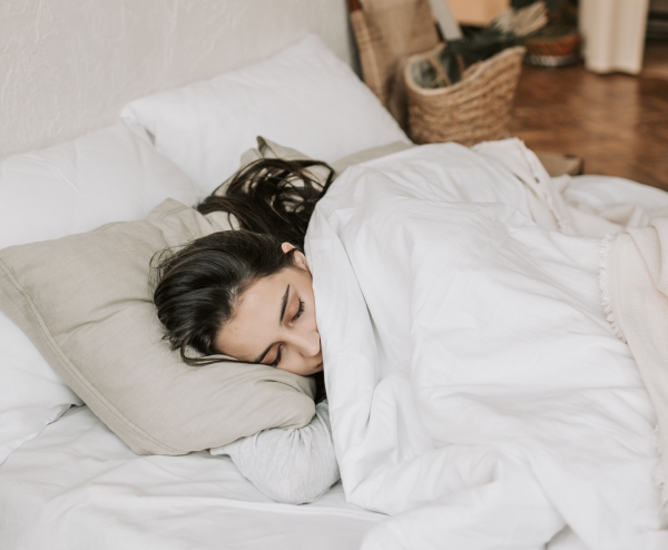 femme qui dort sommeil lit literie oreillers housse gris chambre parquet comment améliorer son sommeil avec une literie adaptée