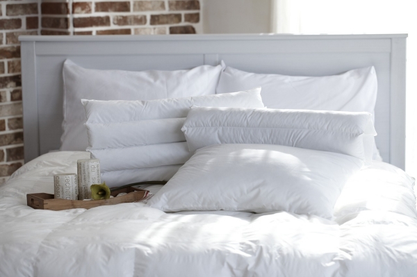 tete de lit bois blanc plateau bois bougies literie oreillers blancs design chambre à coucher avec mur en briques rouges et lit blanc