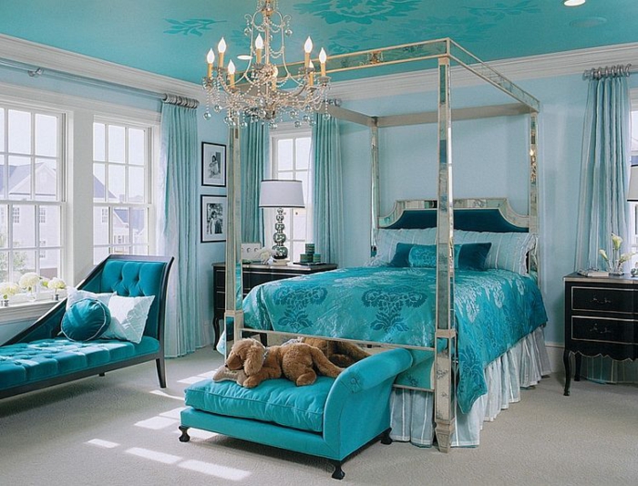 chambre bleu canard avec un lit argenté et lustre