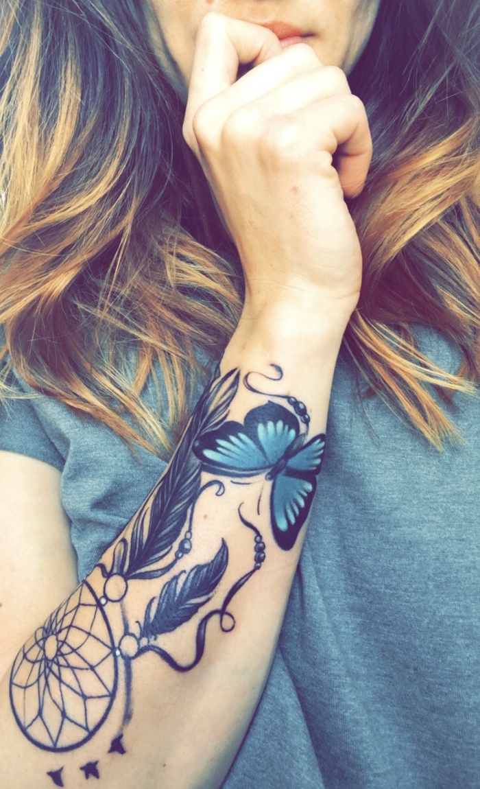 tatouage attrape-rêve bras cerceau et plumes papillon