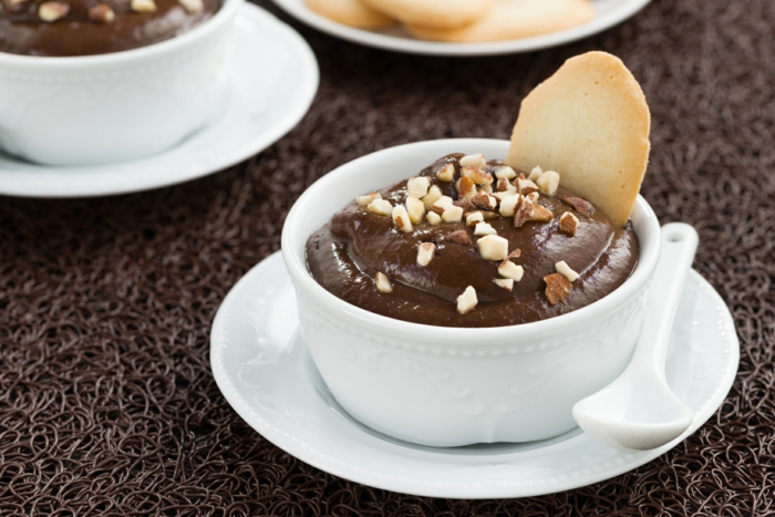 chocolate mousse with biscuits in white cups, close-up