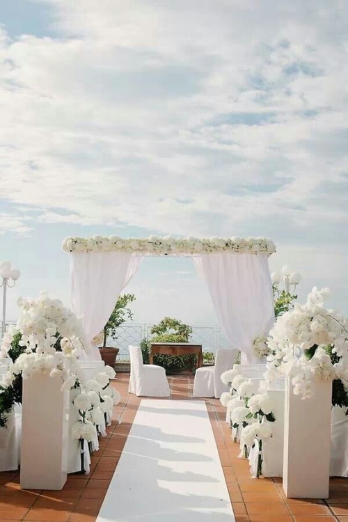 décoration mariage un porche de fleurs blanches et des rideaux blancs