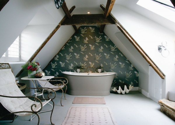 salle de bains sous comble mur habillé de papier peint baignoire grise chaises élégantes