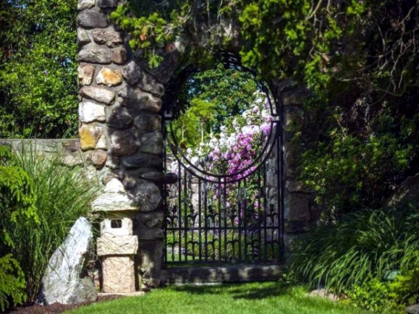 portillon de jardin en fer stylisé et clôture en pierre naturelle