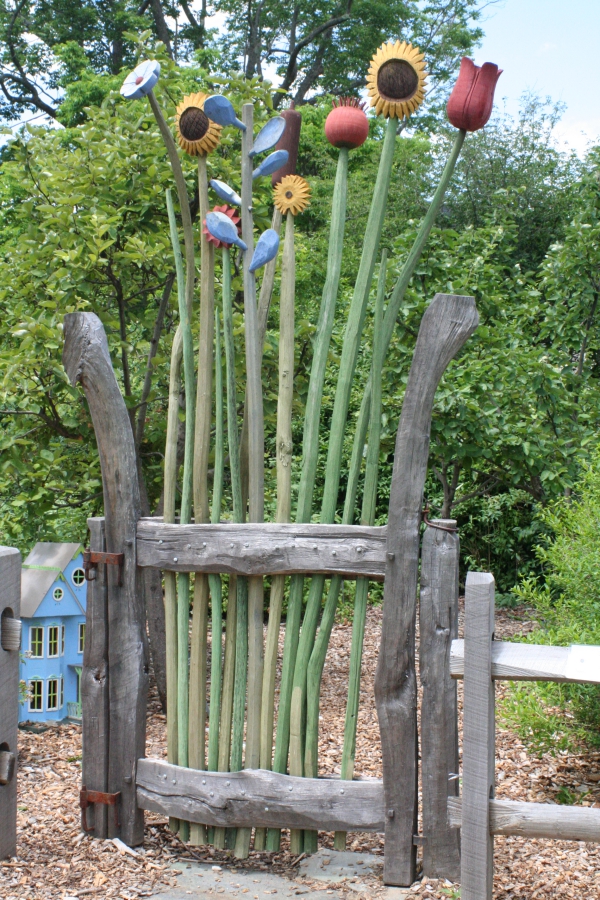 portillon de jardin en piquets de bois avec des éléments décoratifs en plastique