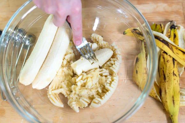 écraser des bananes pour préparer du pain aux bananes
