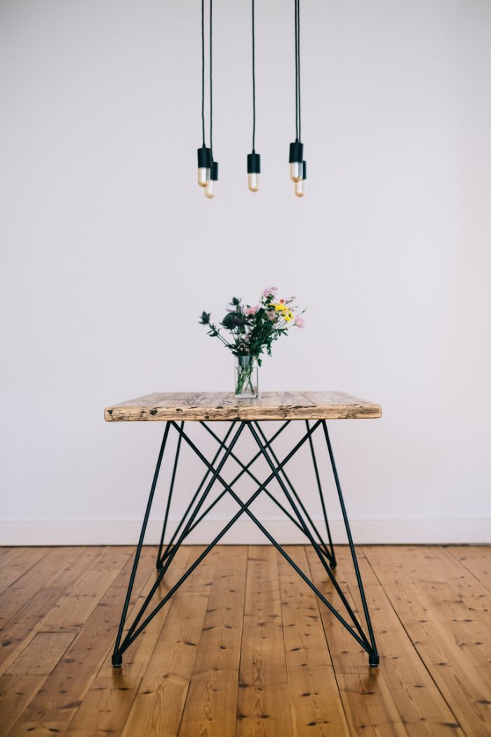 exemple de mobilier durable, table en plateau de bois brut et des pieds e épingle à cheveux sur sol parquet