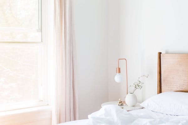 rideau rose clair, lampe ampoule laiton dans chambre blanche ambiance romantique chic
