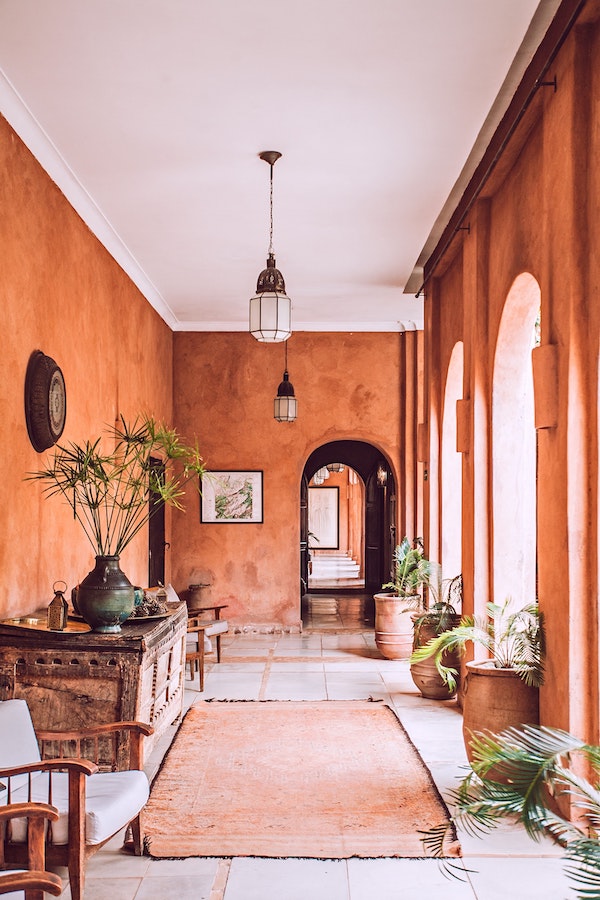 hall d entrée aux murs de couleur terracotta et mobilier vintage marocain