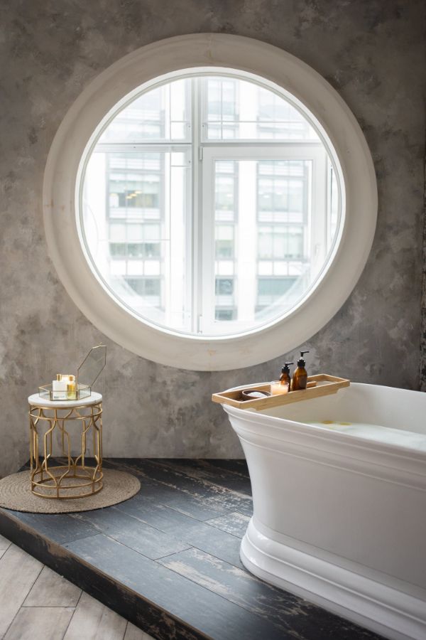 coloris salle de bain, baignoire blanche, miroir rond, revetement parquet