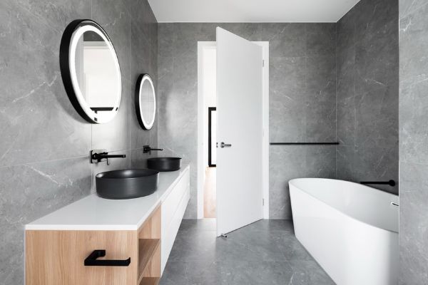 carrelage salle de bain imitation béton ciré, baignoire blanche, meuble salle de bain blanc et bois