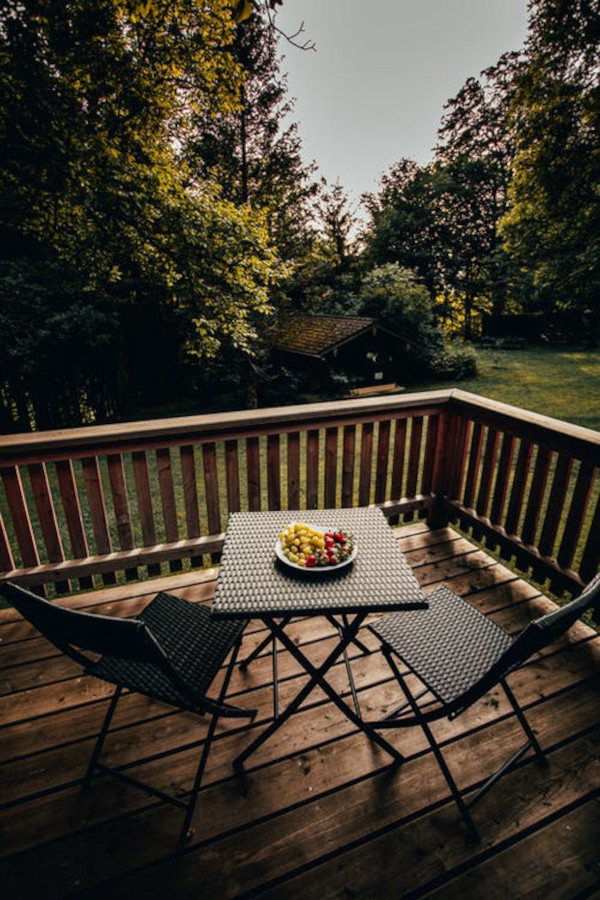 chaises et table sur le balcon vue sur le jardin